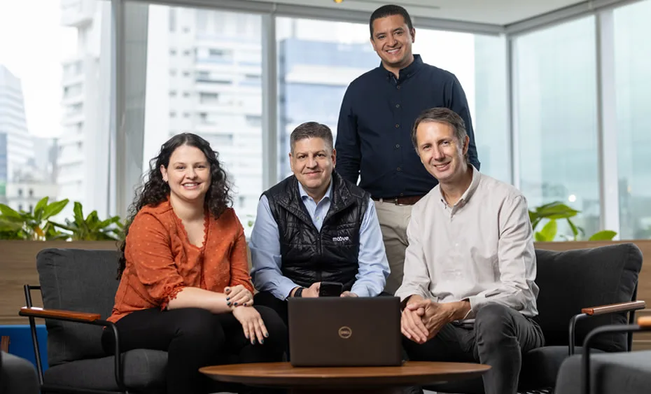 Time da Moove reunido em torno de um notebook no escritório