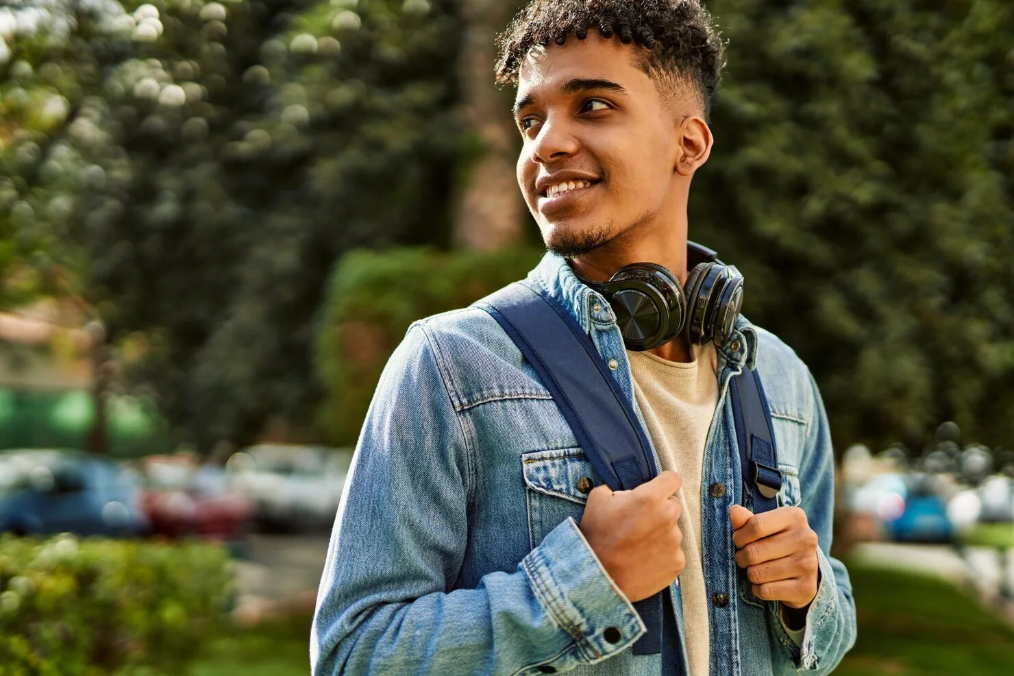 Estudante brasileiro que estuda no exterior, de mochila e fones de ouvido, sorrindo: Programa - Summer Job Moove 2027